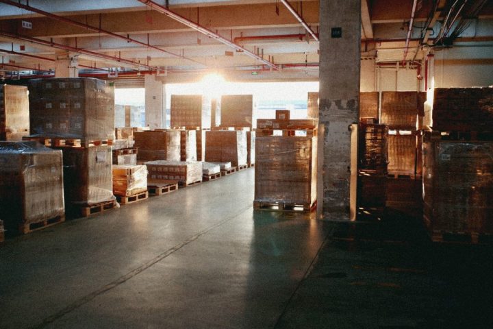 Paleți cu marfă într-un depozit, la ușa de încărcare — marfa livrată devine factura de încasat